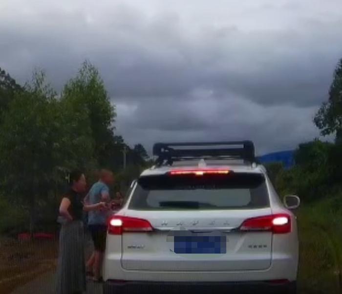 奔驰车上的男女下车和“平头哥”沟通让路，女司机左手中疑拿着一物品。